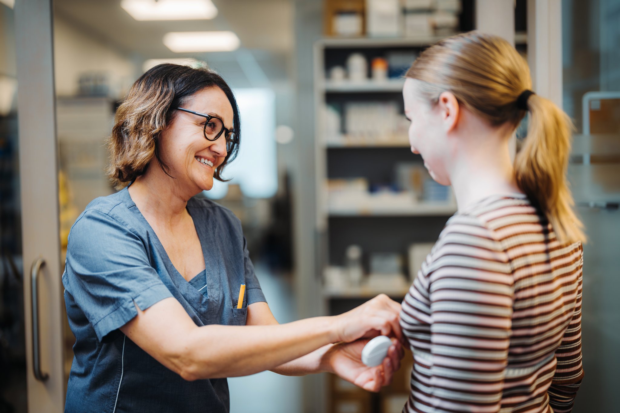 En kvinne som viser en kvinne noe på telefonen